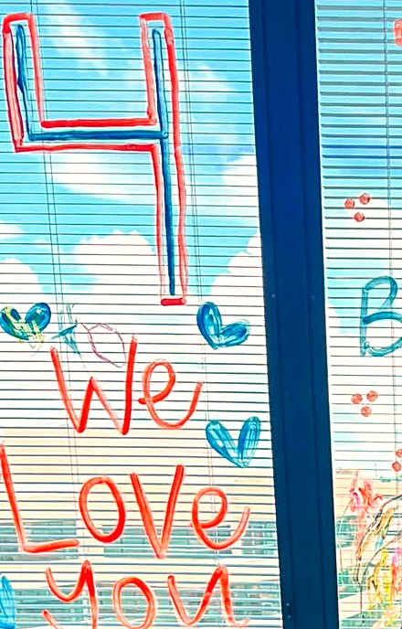 Hand-painted window art in the hospital room reading We Love You