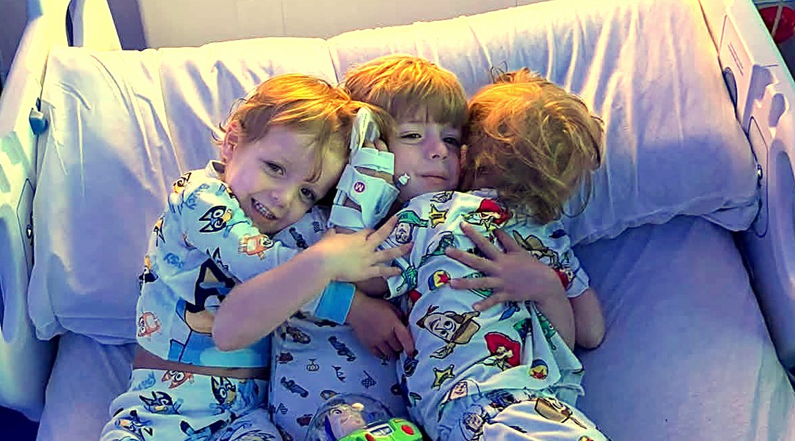 Carter and his brothers hugging at sunset in his hospital room